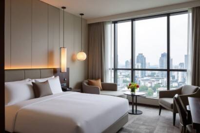 Luxurious hotel room with city view, king-size bed, and seating area.